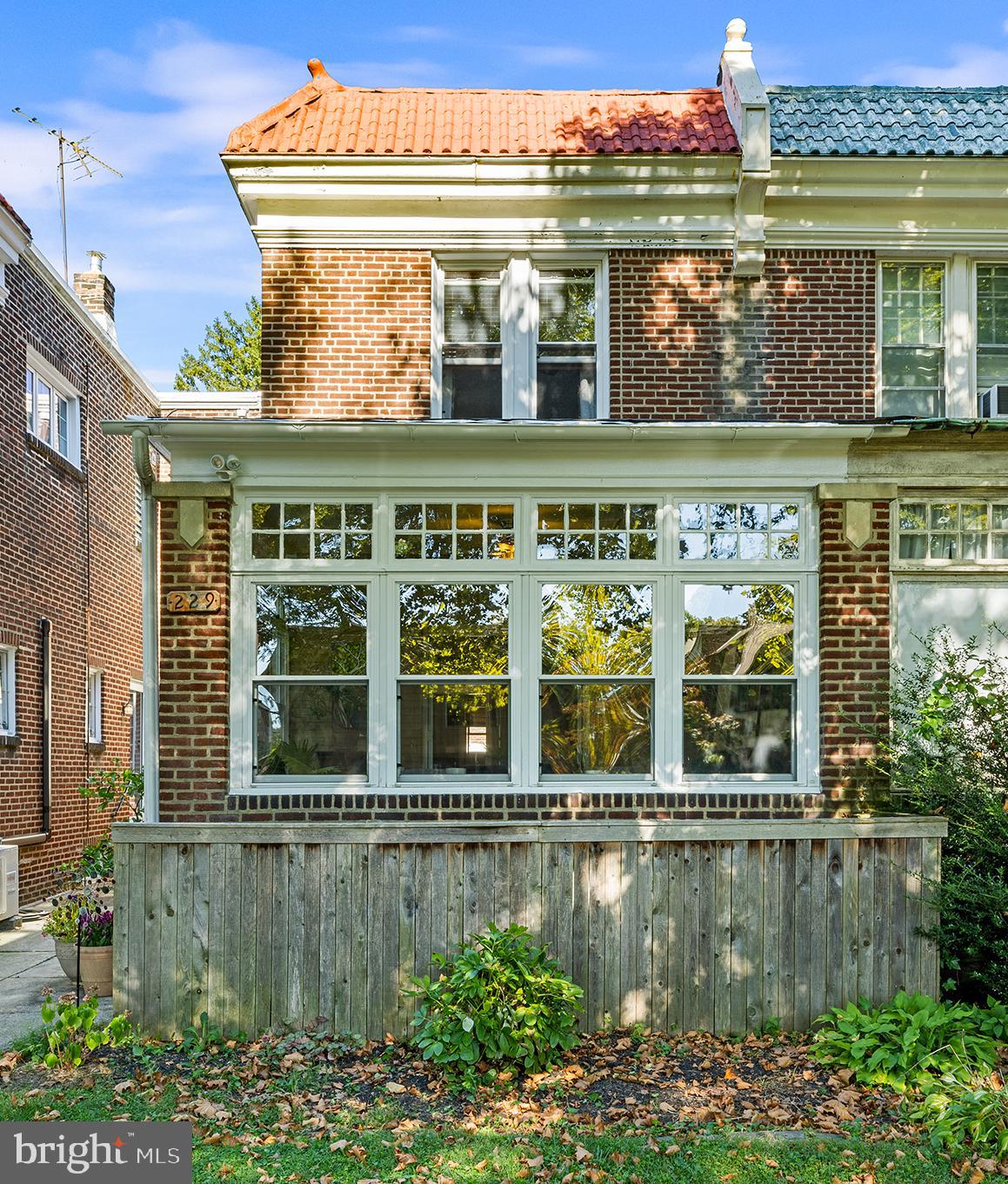 a front view of a building with a garden and plants