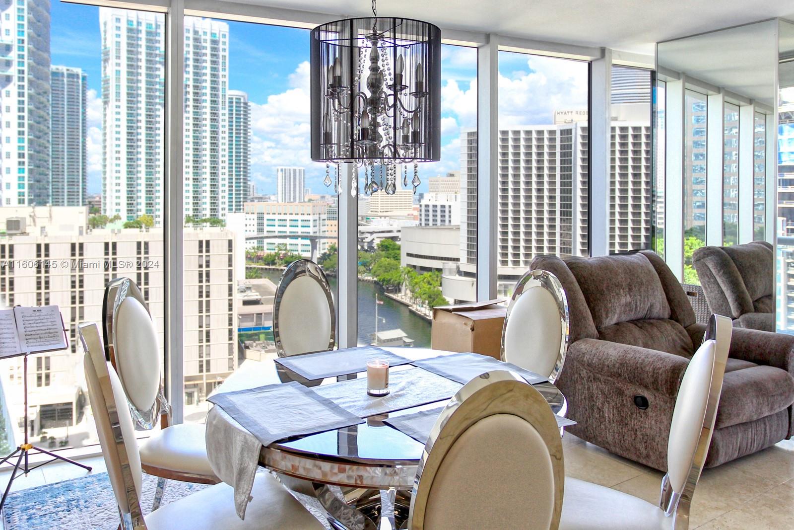 a dining room with furniture a flat screen tv and a large window