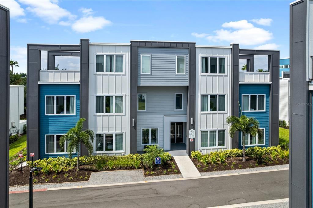 a front view of a residential apartment building with a yard