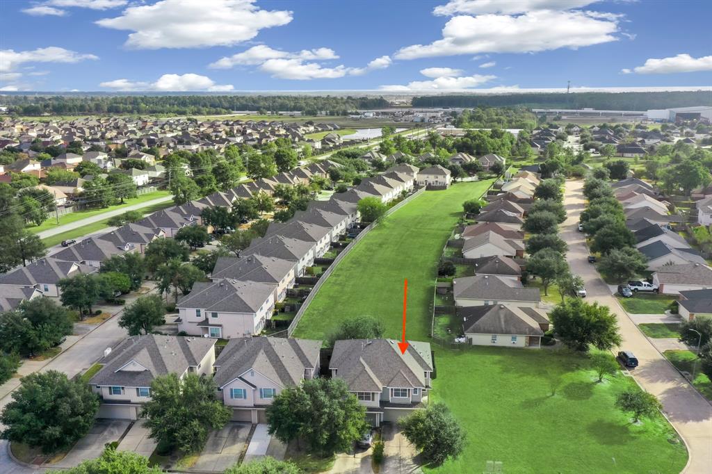 an aerial view of residential houses with outdoor space and ocean view