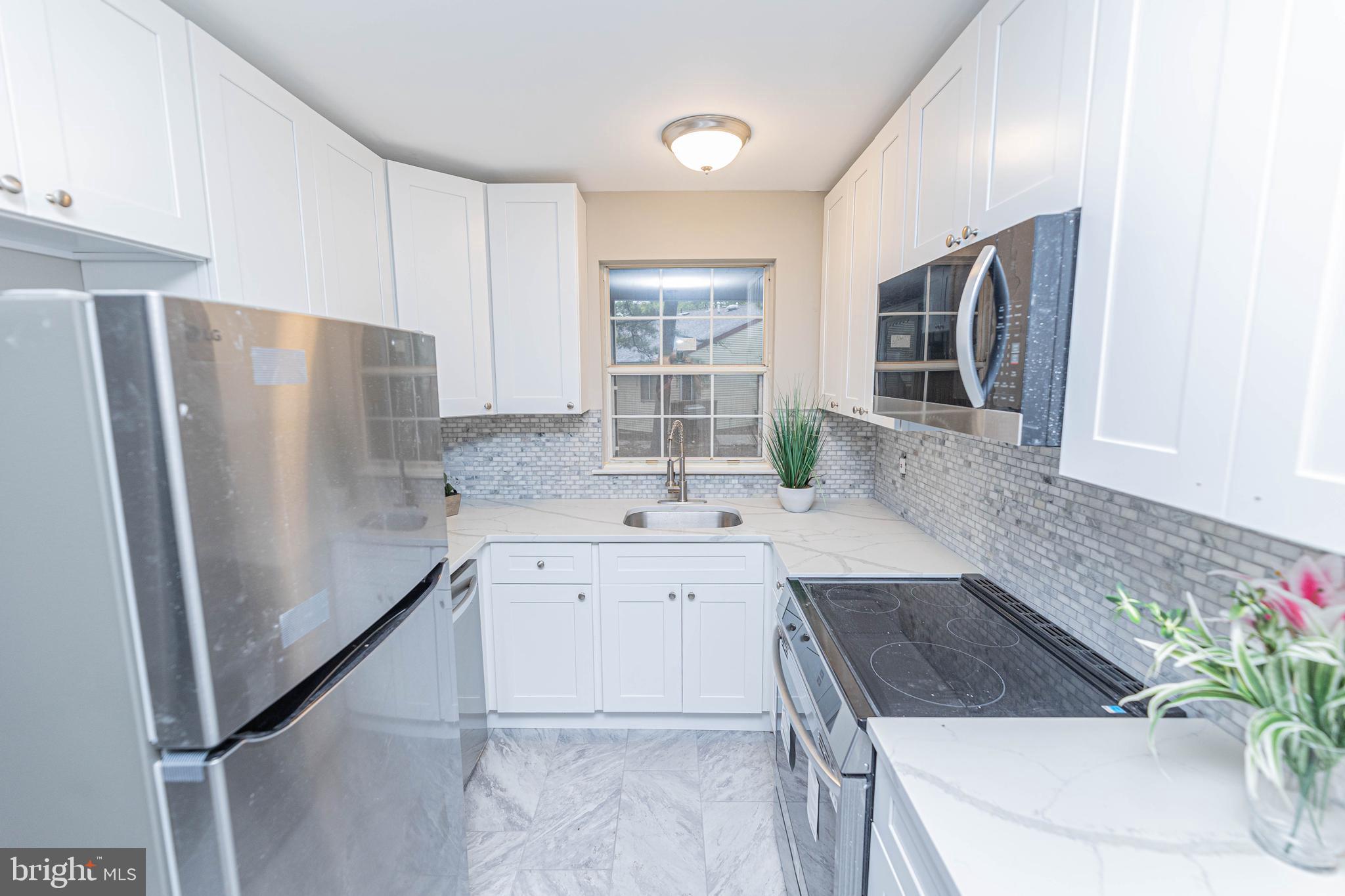 a kitchen with granite countertop a sink stove and refrigerator