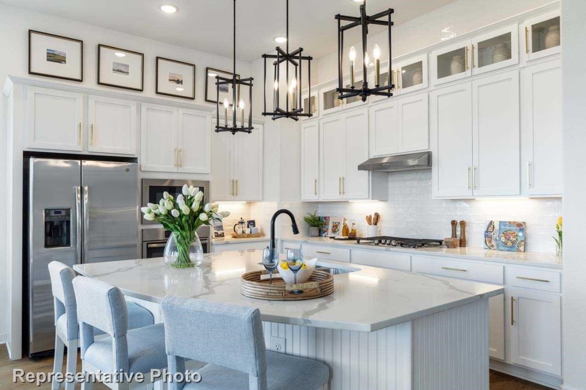 a kitchen with stainless steel appliances kitchen island granite countertop a sink and cabinets