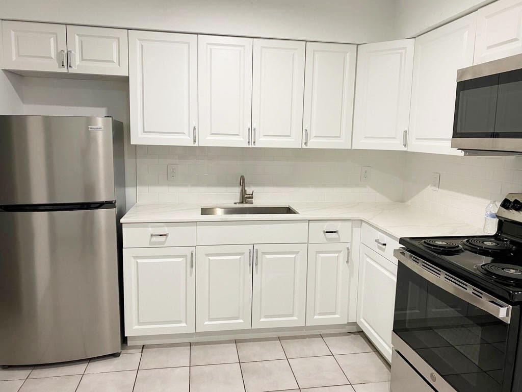 a kitchen with white cabinets and stainless steel appliances