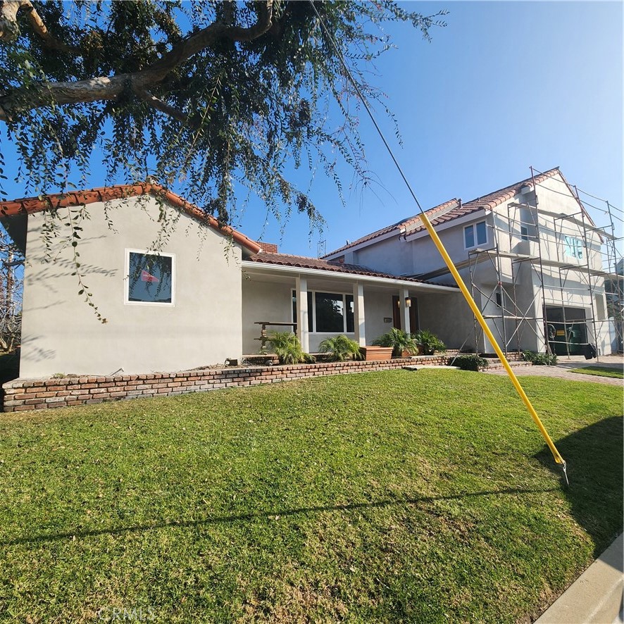 a view of a house with backyard and sitting area