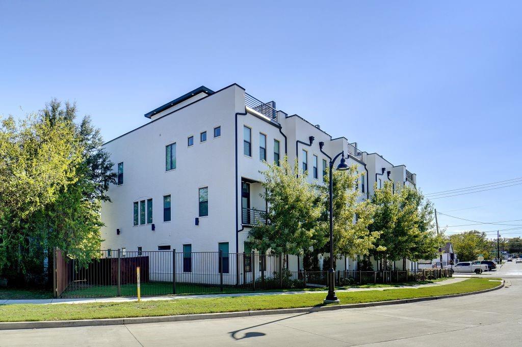 a view of a big building with a big yard and large trees