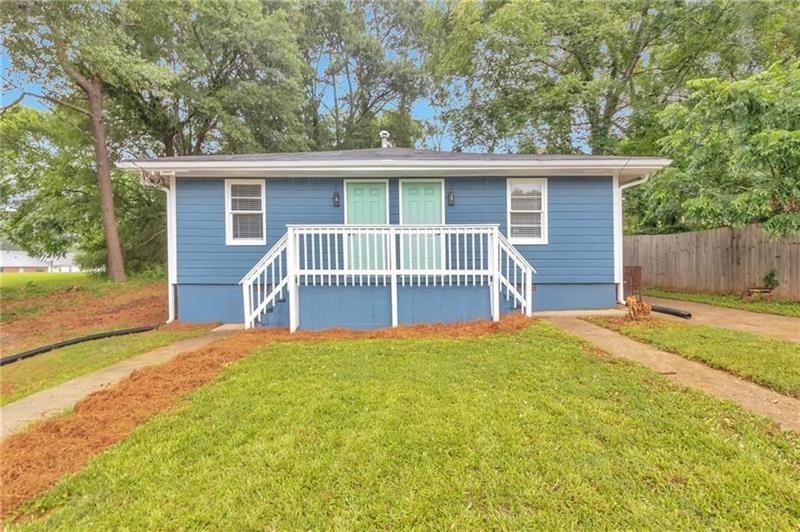 a view of a house with a yard and wooden fence