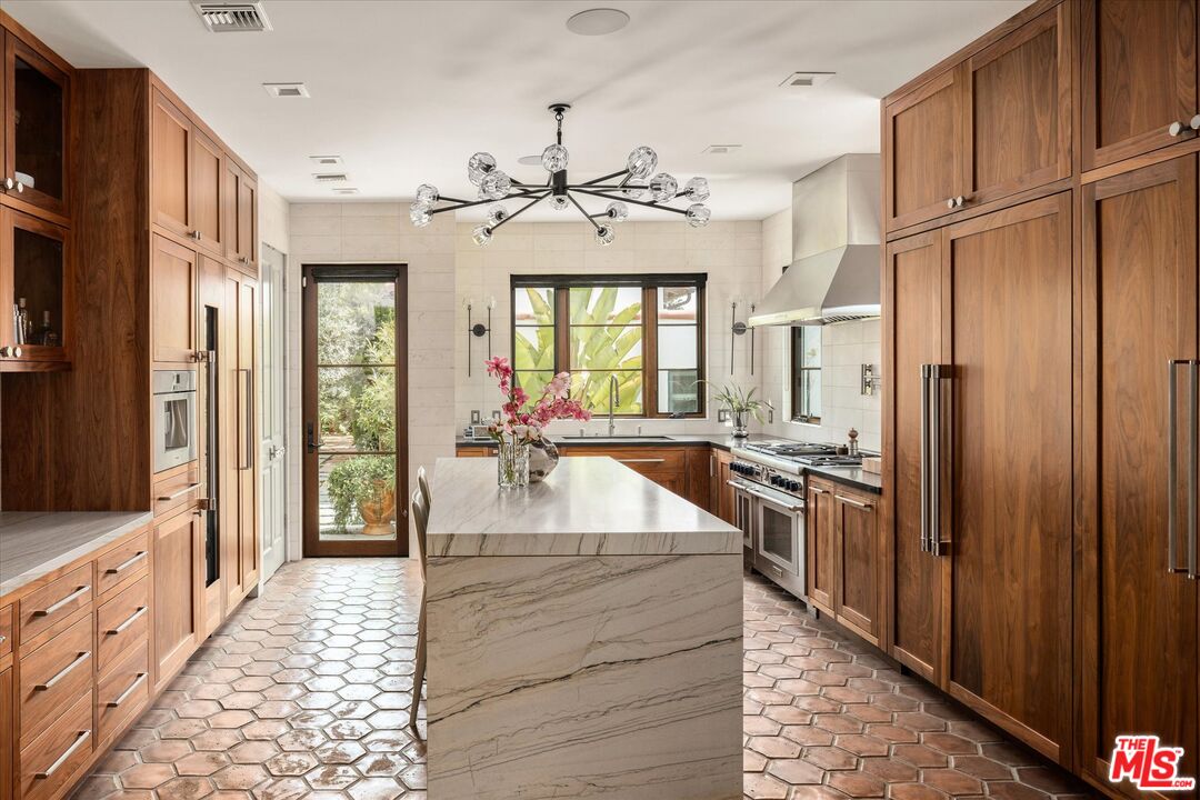 a large kitchen with kitchen island granite countertop a large window and stainless steel appliances