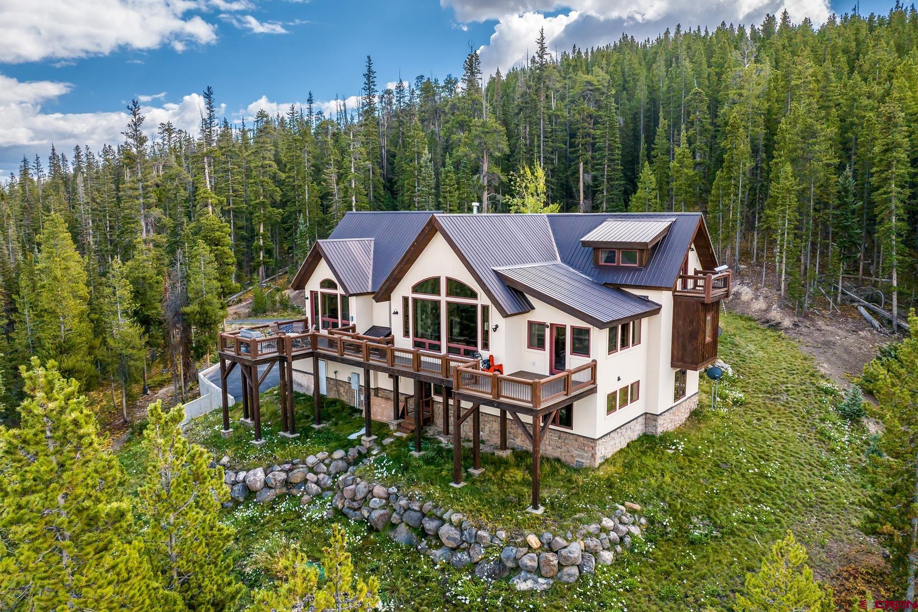 a aerial view of a house with balcony and trees al around