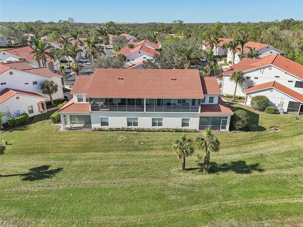 an aerial view of residential houses with outdoor space and trees