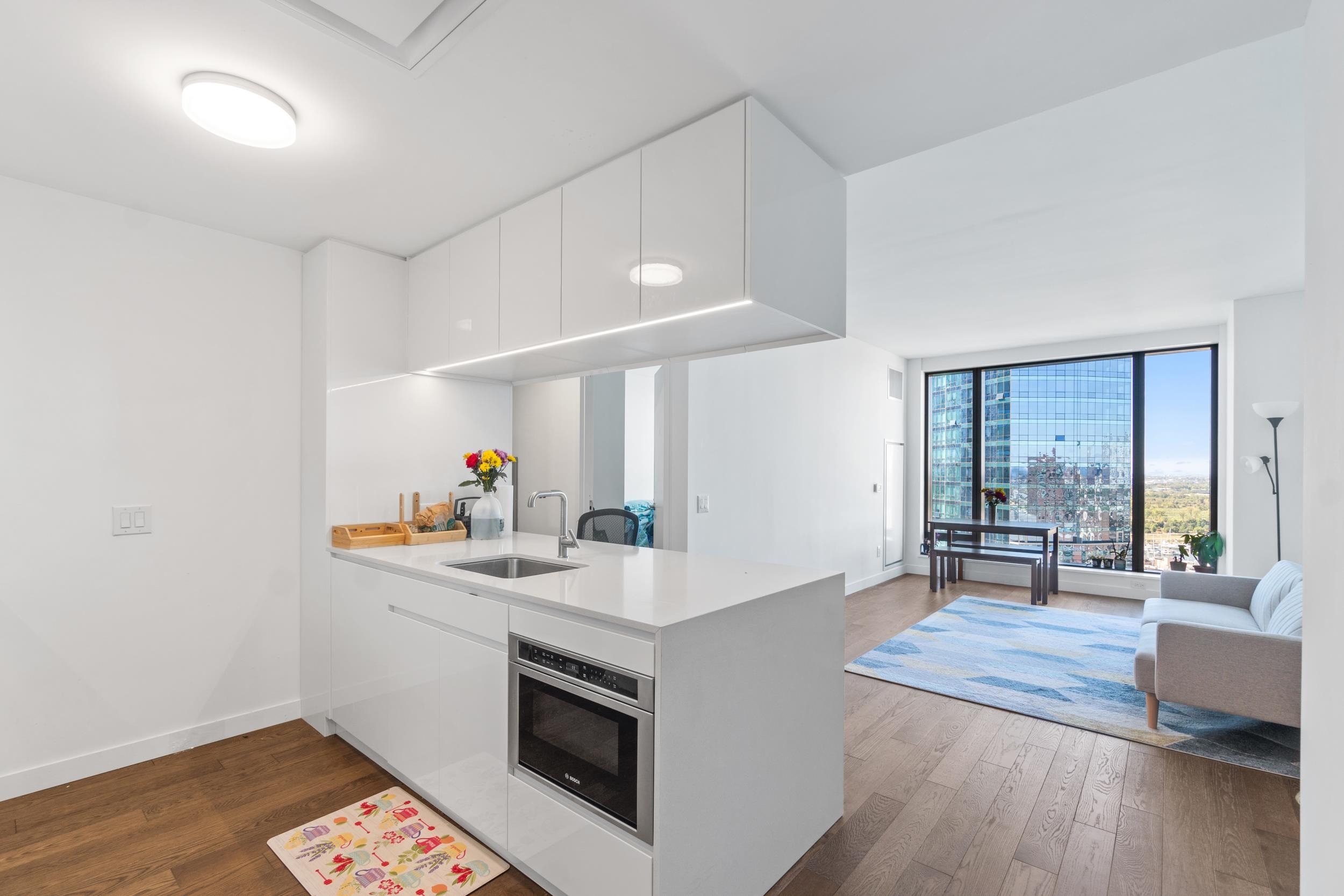 a kitchen with a sink cabinets and wooden floor