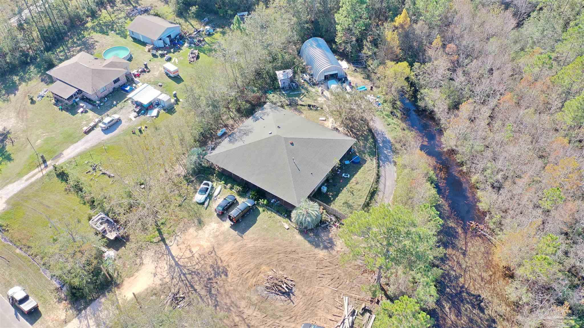 an aerial view of a house with a yard and trees