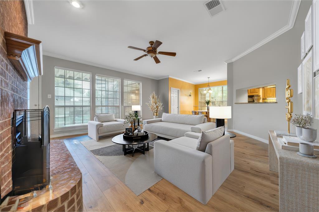 Virtual Staging - Living room with crown molding, ceiling fan, a brick fireplace, and light hardwood / wood-style flooring