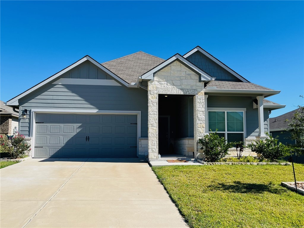 View of front of home with a front lawn and a gara