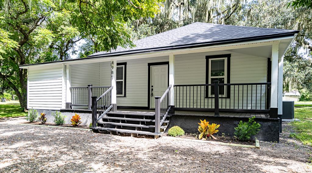 a view of a house with a yard and wooden fence