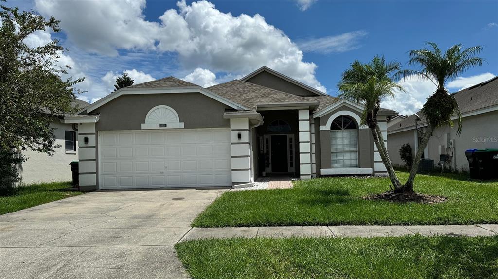 a front view of a house with a yard and garage