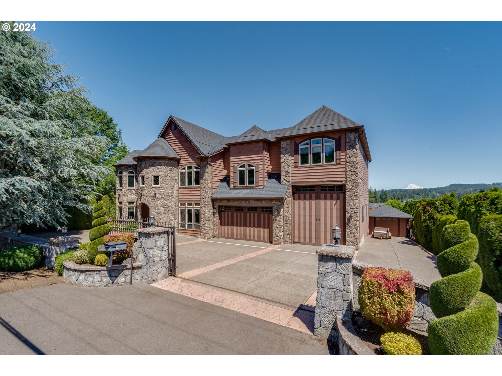 a view of a big house with wooden fence