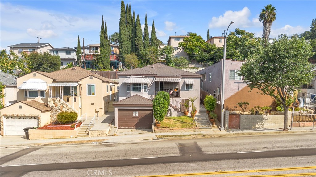 a front view of a residential houses with yard and tree s