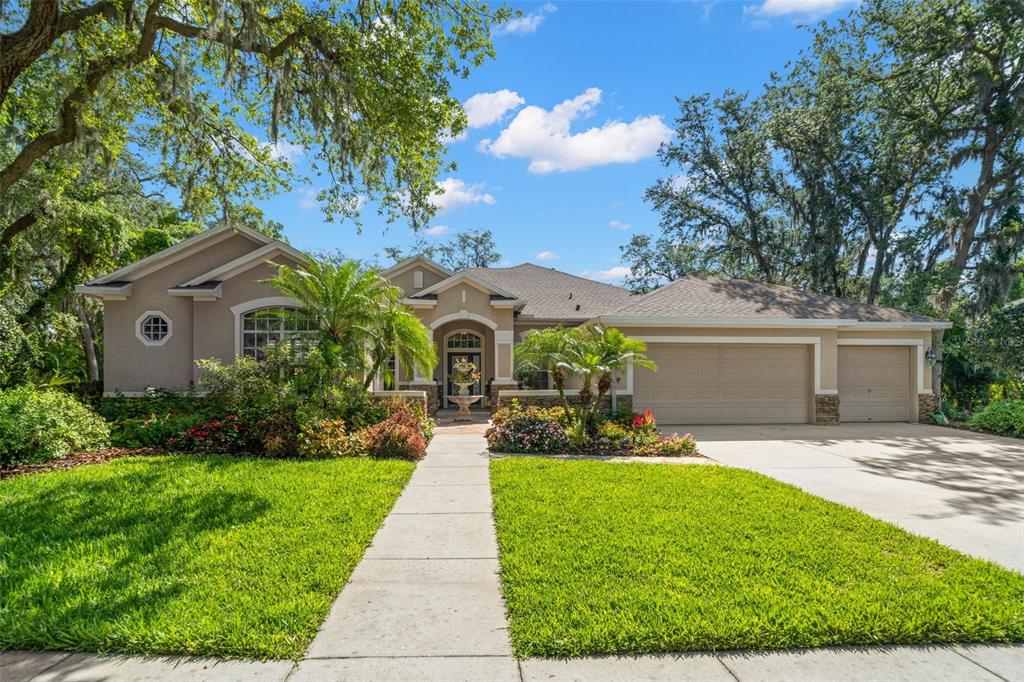 a front view of a house with a yard and potted plants