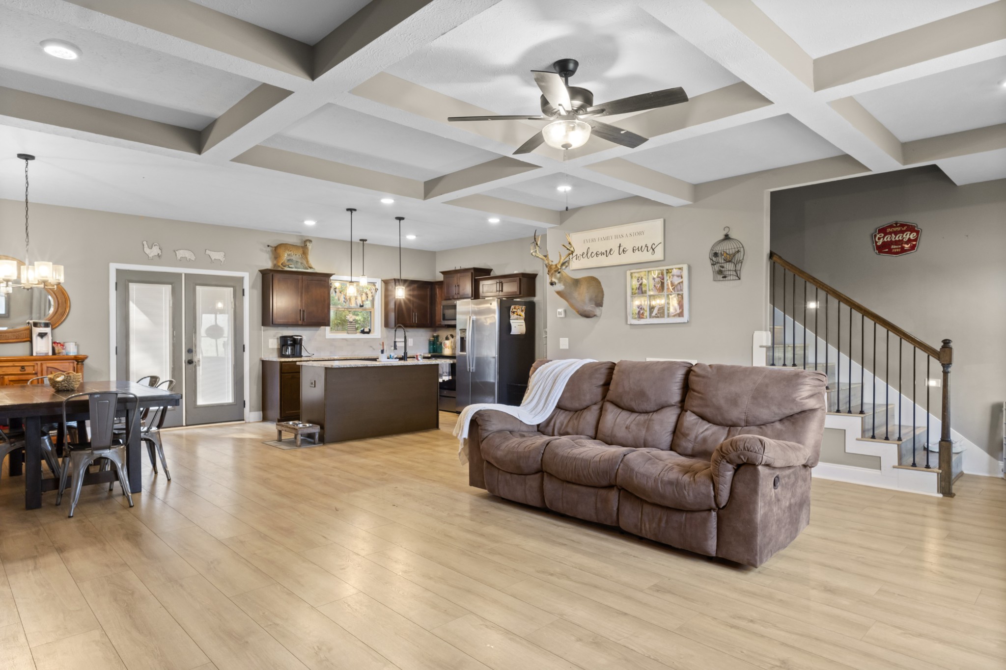 a living room with furniture kitchen view and a wooden floor