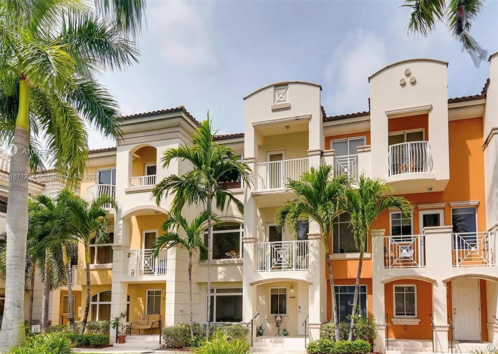 a front view of multi story residential apartment building with a yard