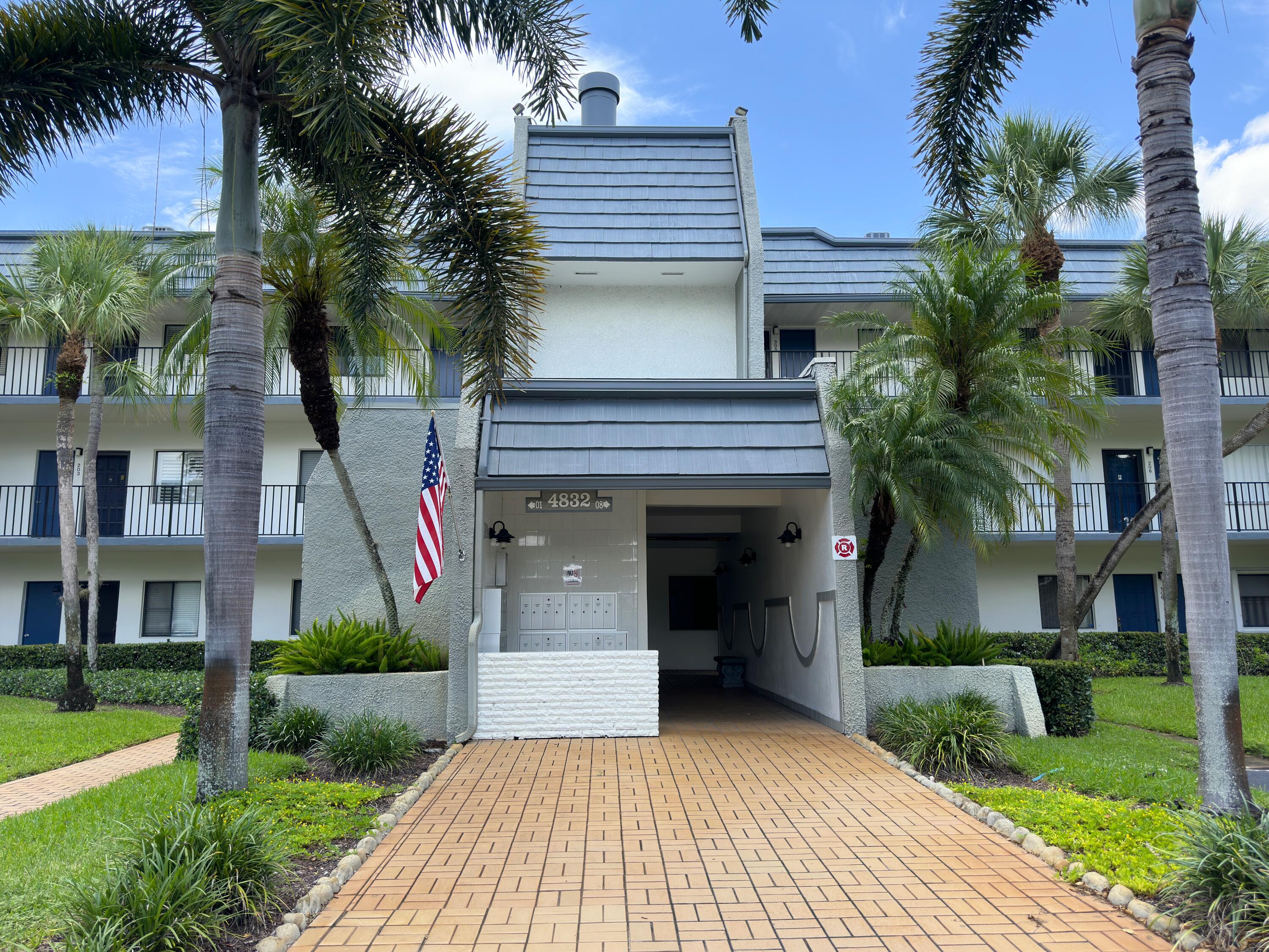 a view of a house with a yard and palm trees