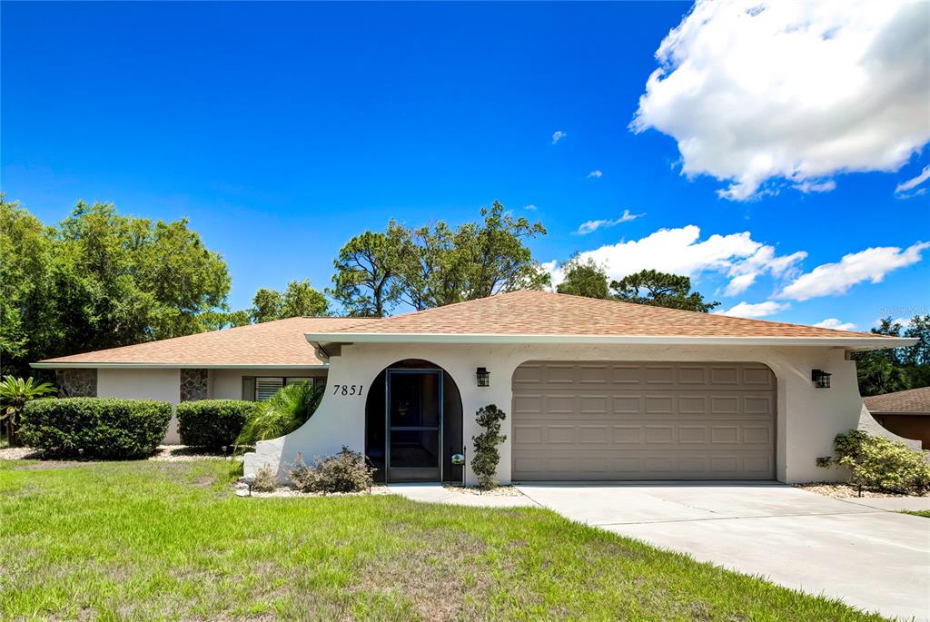 a front view of a house with yard and garage