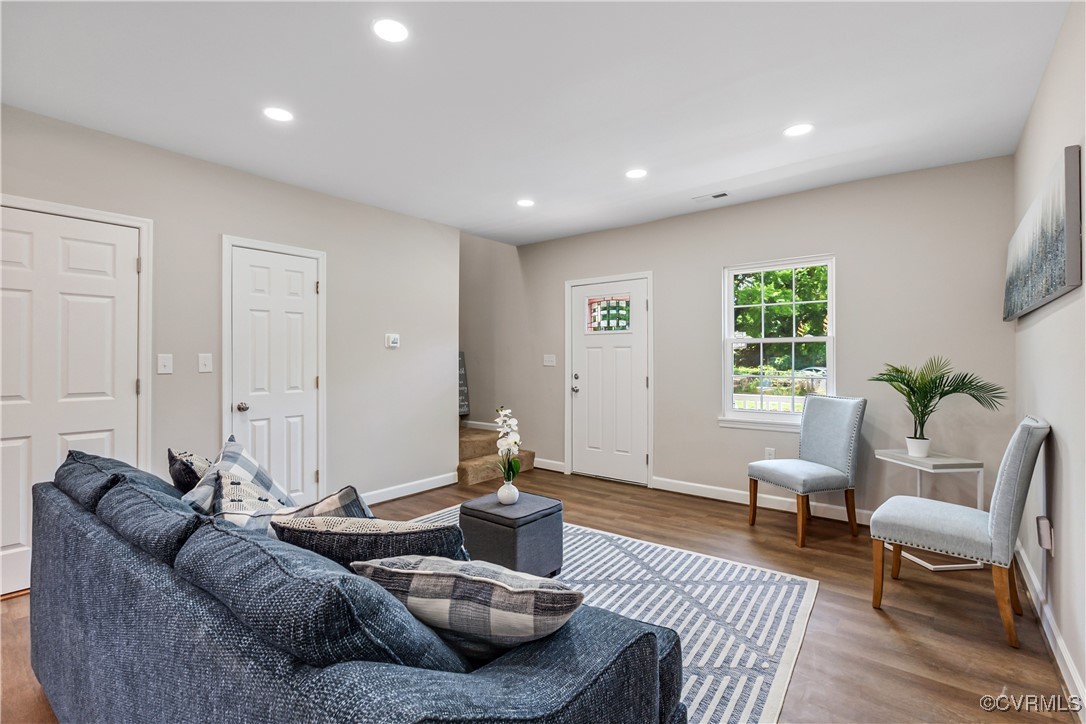 a living room with furniture and a wooden floor