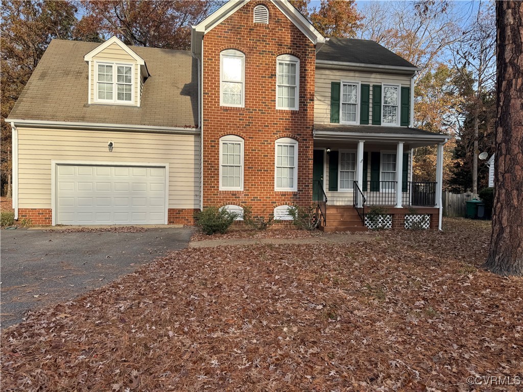 View of front of house featuring a porch and a gar