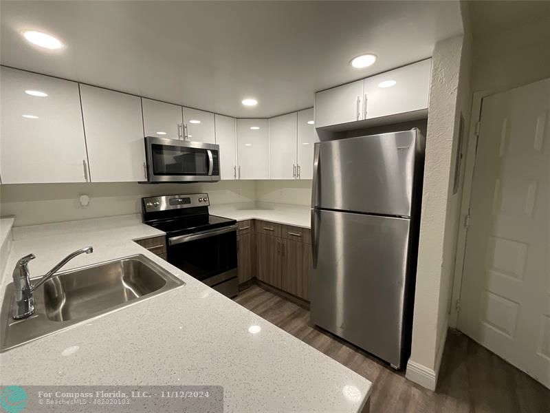 a kitchen with a refrigerator a sink and cabinets