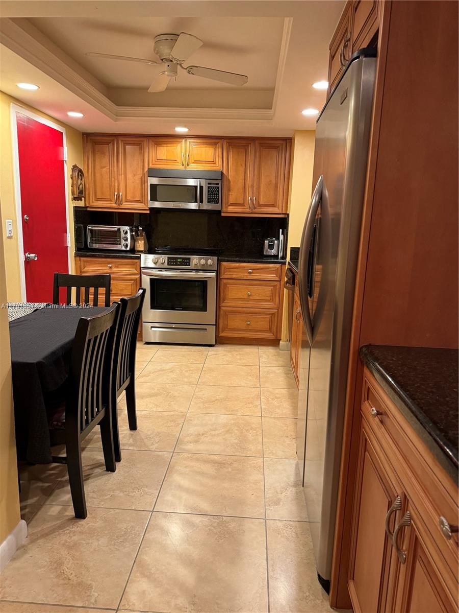 a kitchen with stainless steel appliances granite countertop a refrigerator and a stove top oven