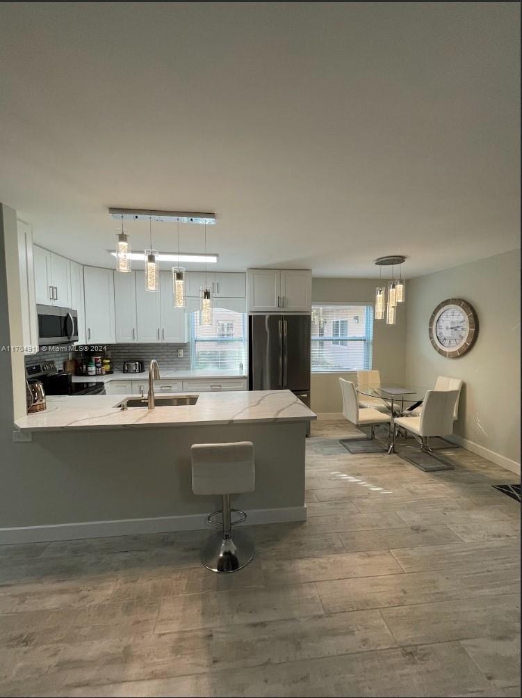 a living room with couches and kitchen view with wooden floor