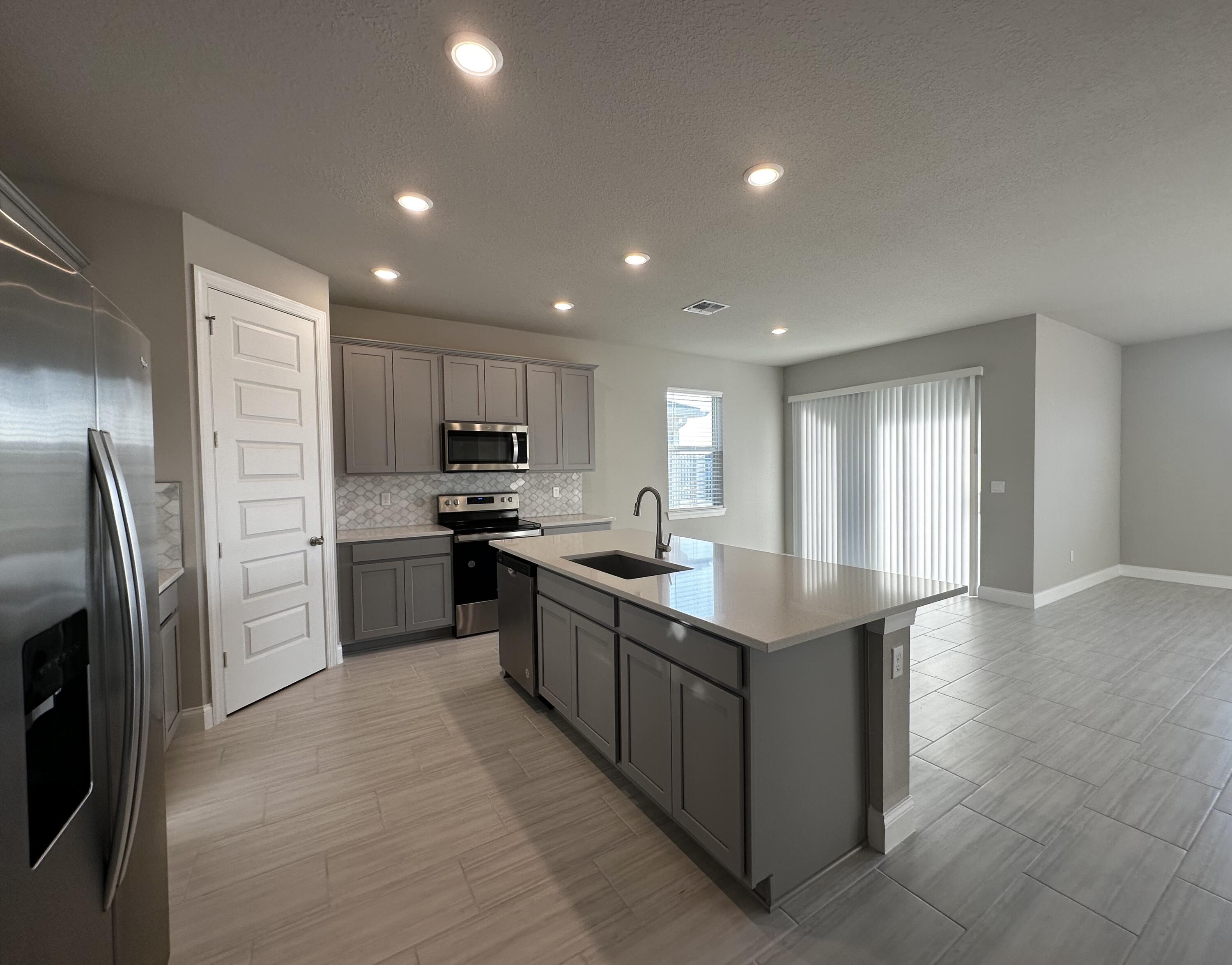 a kitchen with refrigerator cabinets and wooden floor