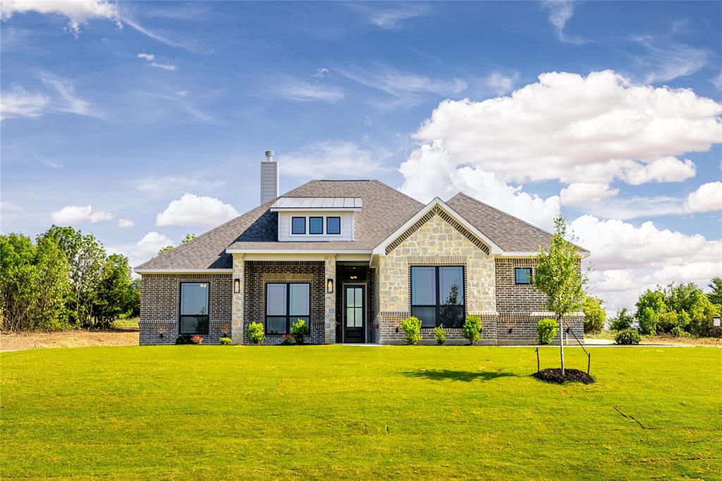 a front view of house with yard and lake