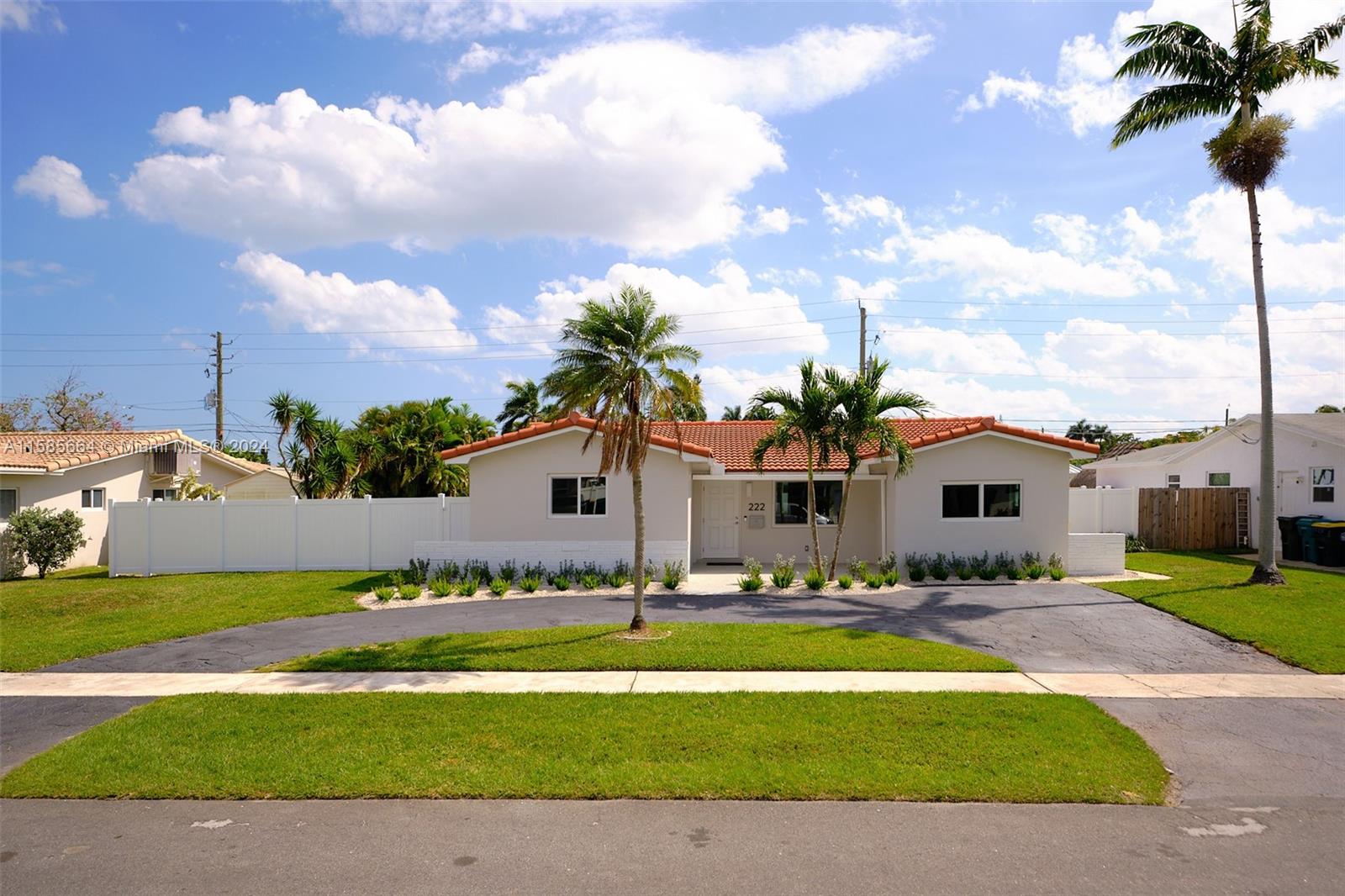 a front view of a house with a garden and yard