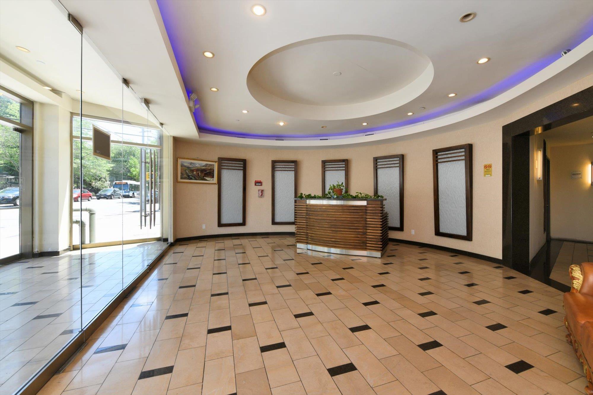 a view of a hallway with wooden floor and a chandelier