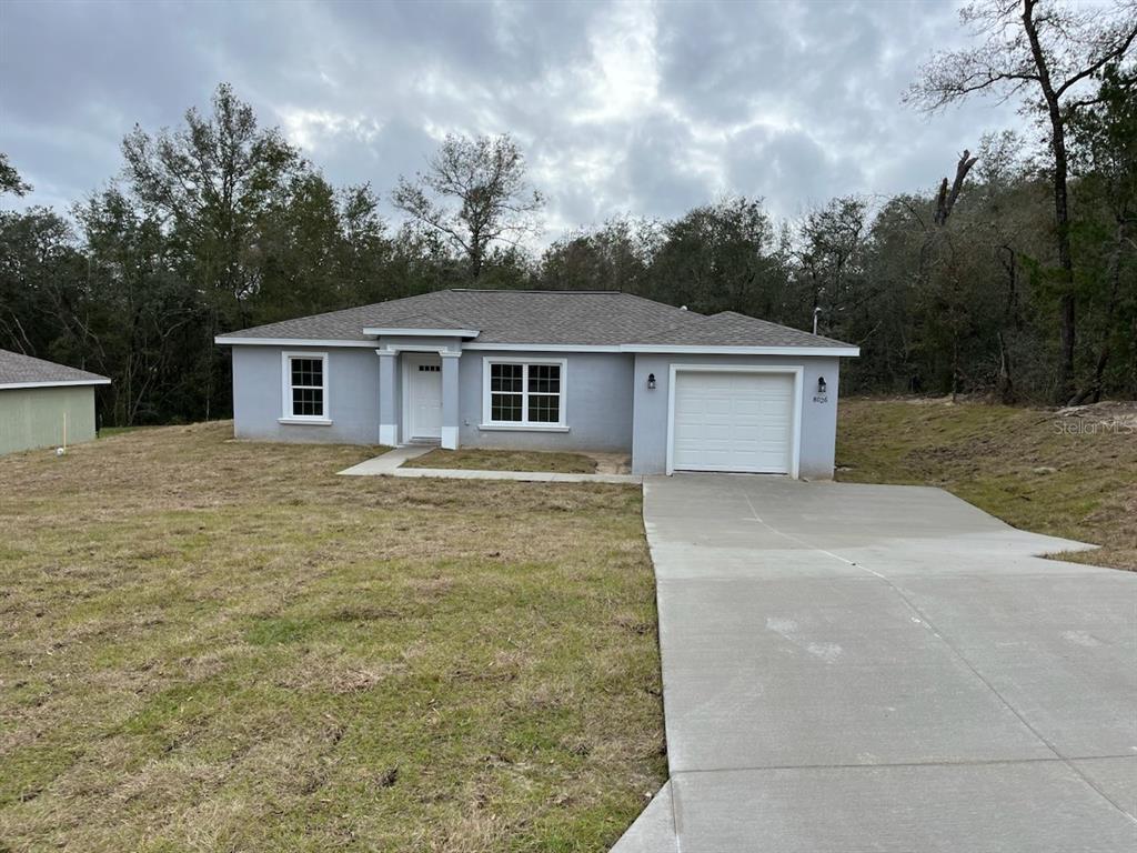 a front view of house with yard and trees