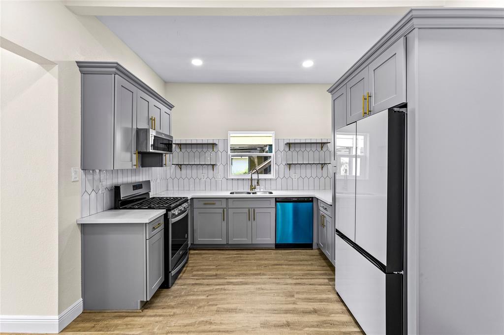 a kitchen with stainless steel appliances granite countertop a refrigerator stove and sink