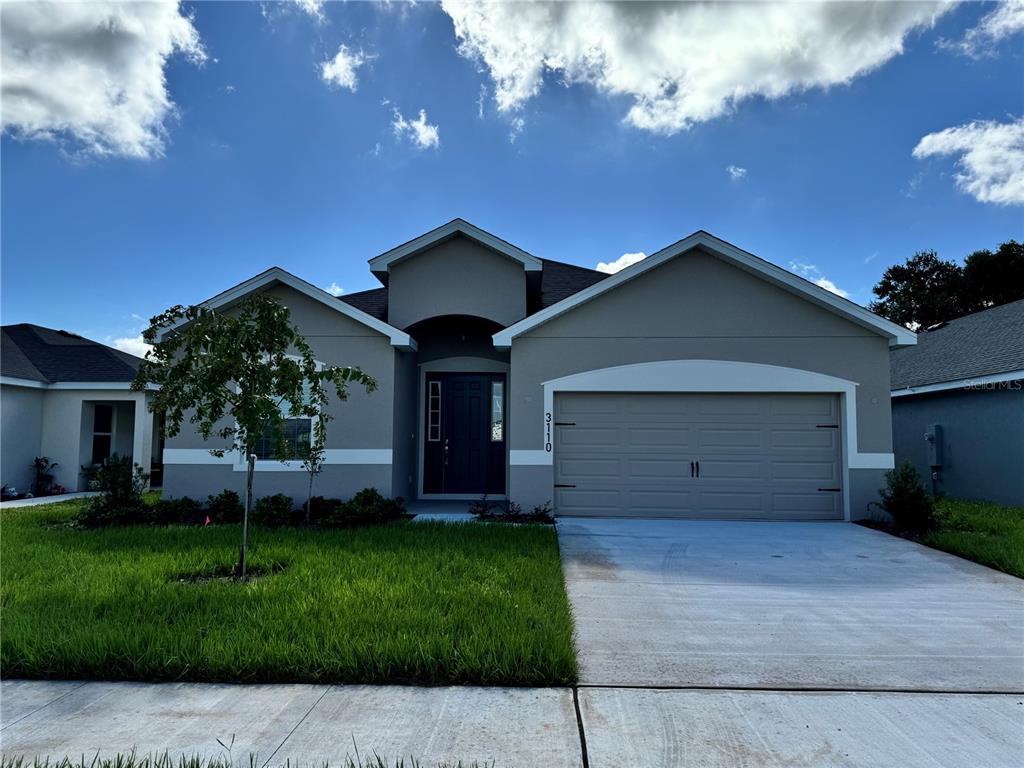 a front view of a house with a yard and garage