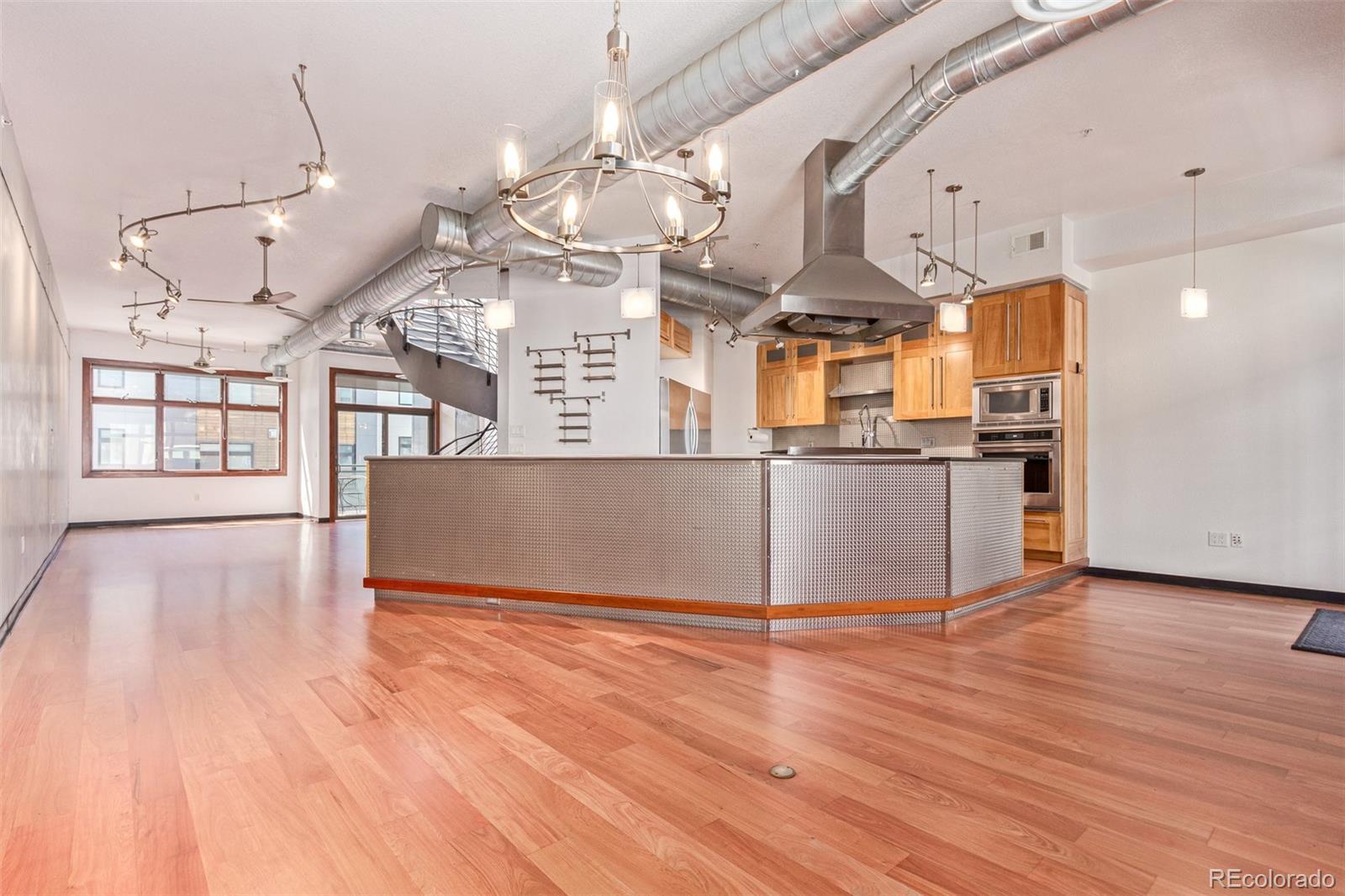 a view of a kitchen with stainless steel appliances granite countertop a wooden floor