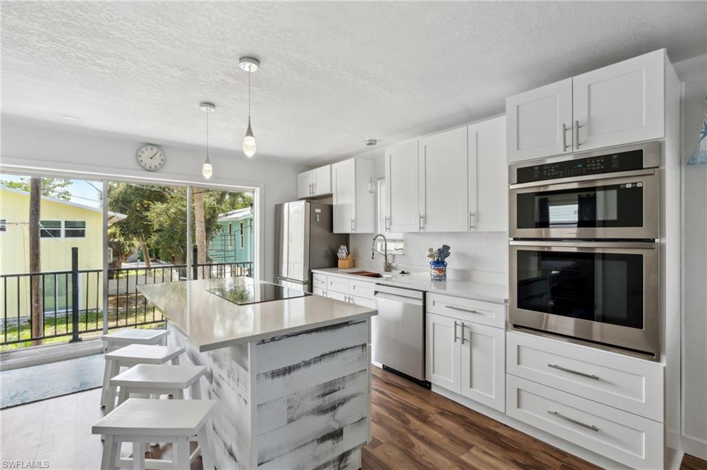 Kitchen featuring a kitchen island, stainless steel appliances, and white cabinets