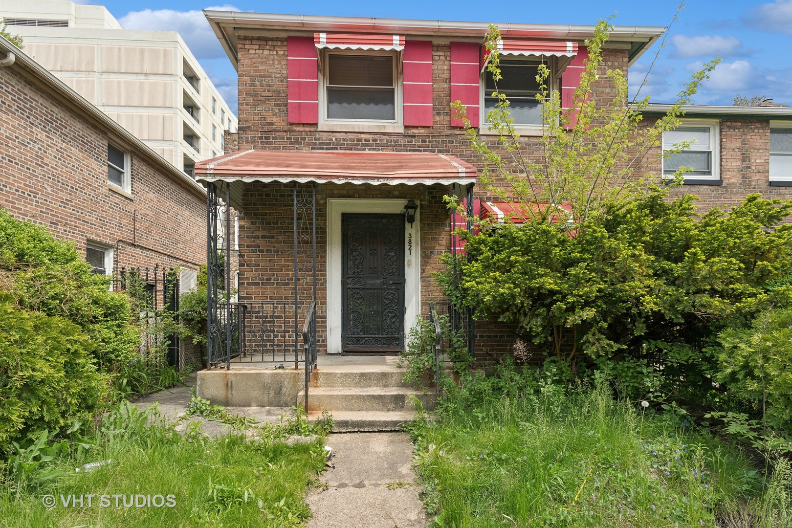 a view of brick building with a yard and plants