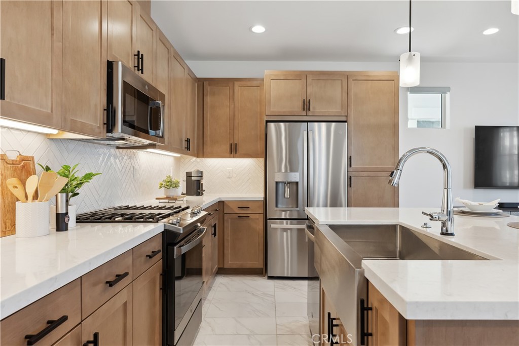 a kitchen with stainless steel appliances granite countertop a sink stove and refrigerator