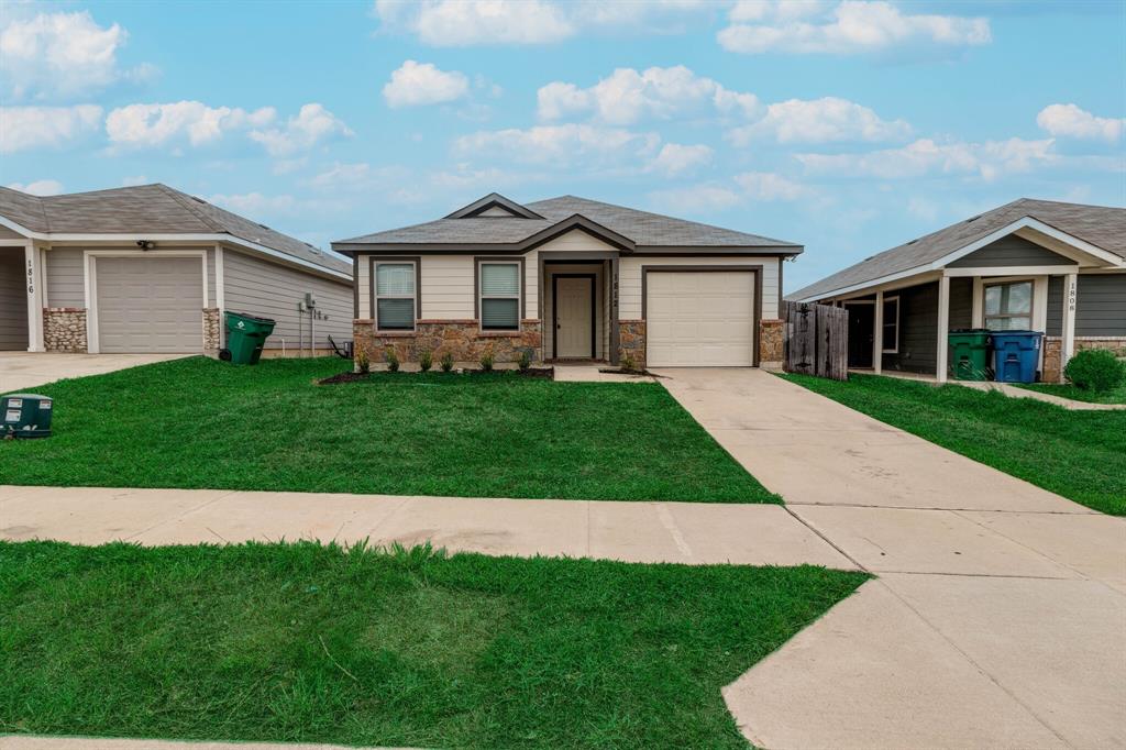 a front view of a house with a garden and yard