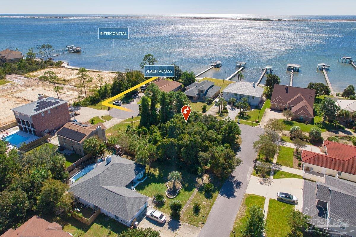 an aerial view of a house with a yard and lake view