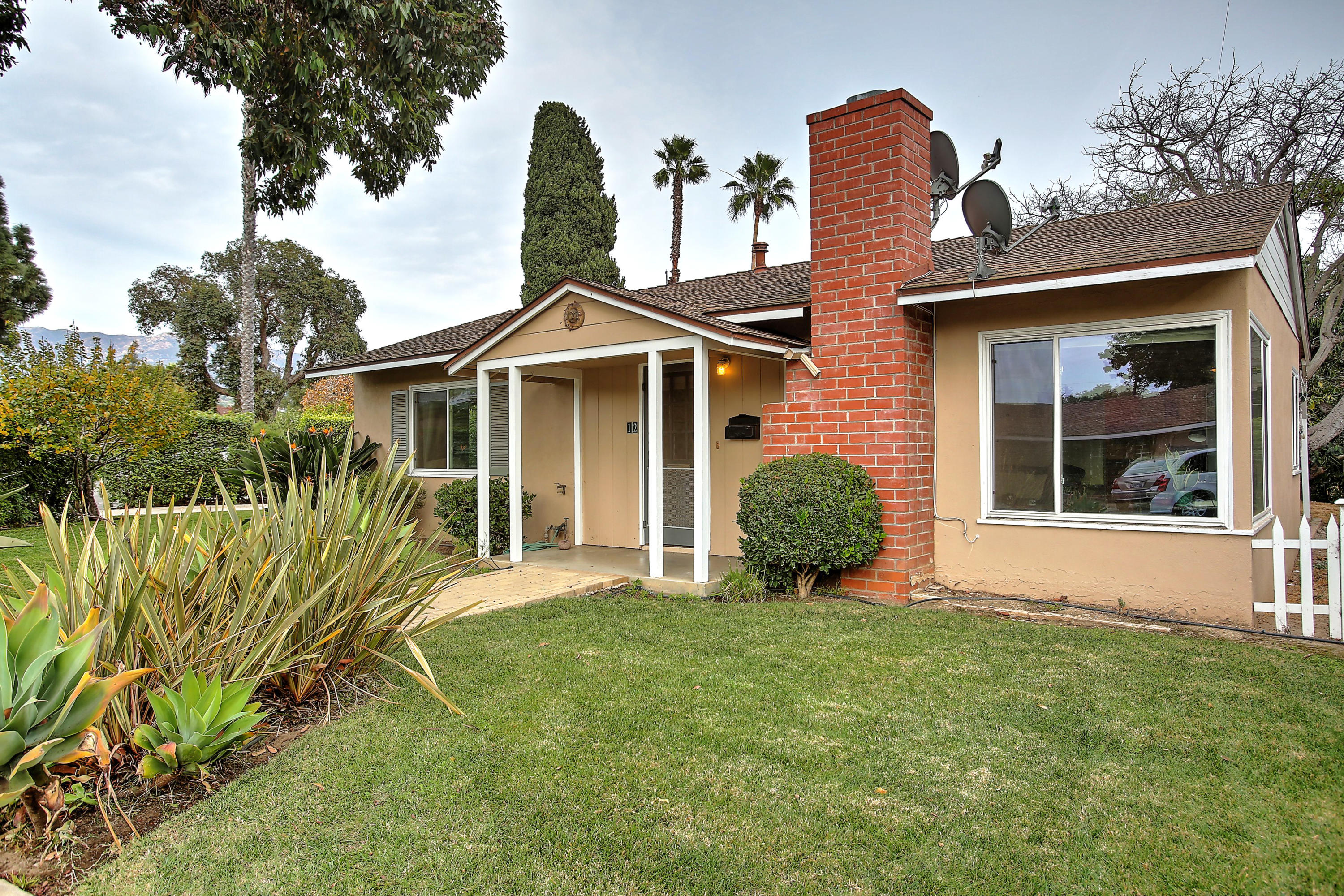 a front view of a house with a garden