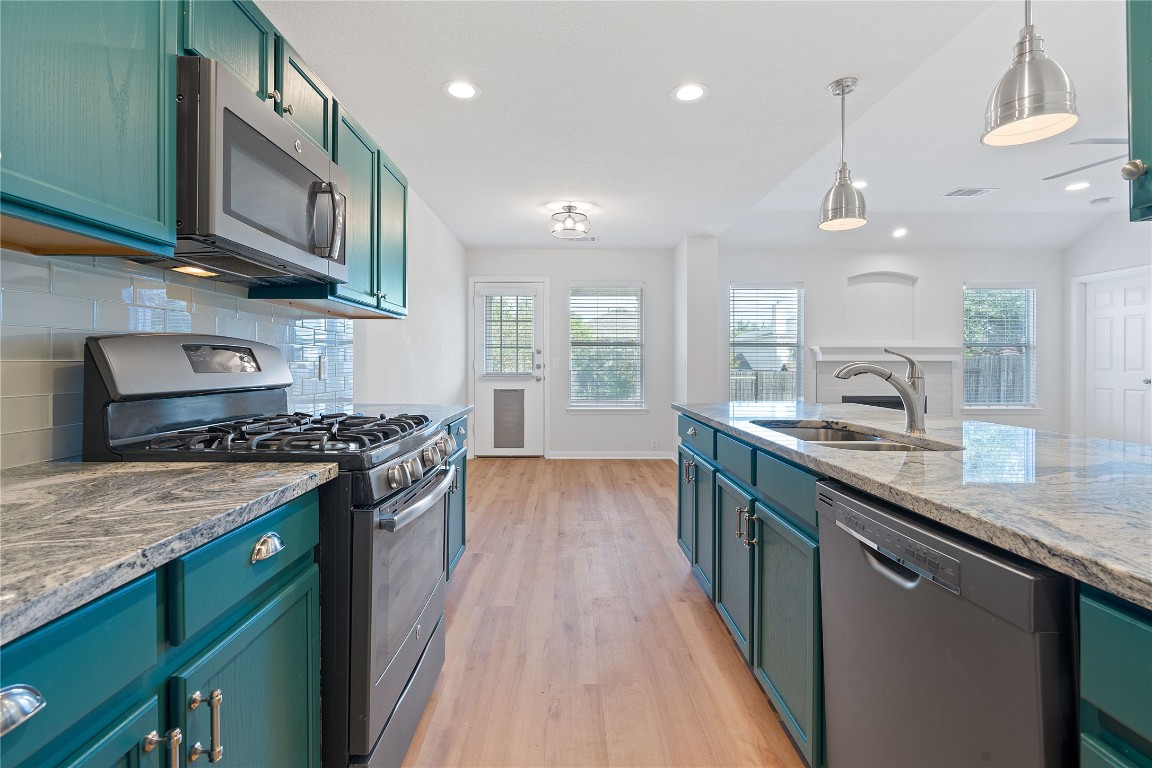 a kitchen with stainless steel appliances granite countertop a stove and a sink