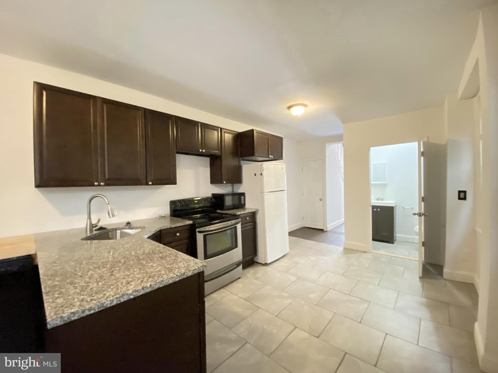 a kitchen with stainless steel appliances granite countertop a sink refrigerator and cabinets