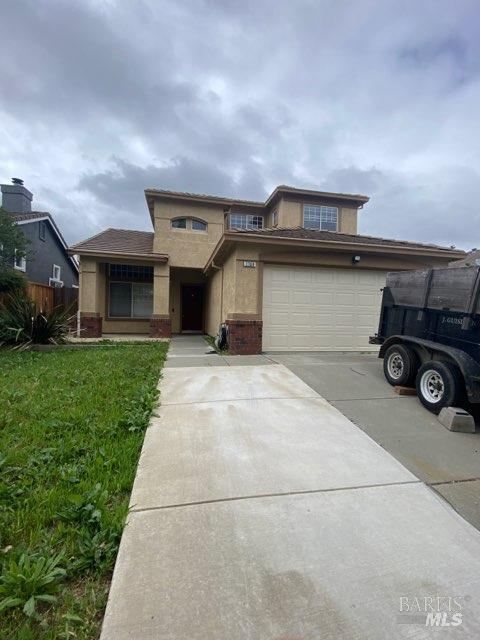 a front view of a house with a garden and parking space