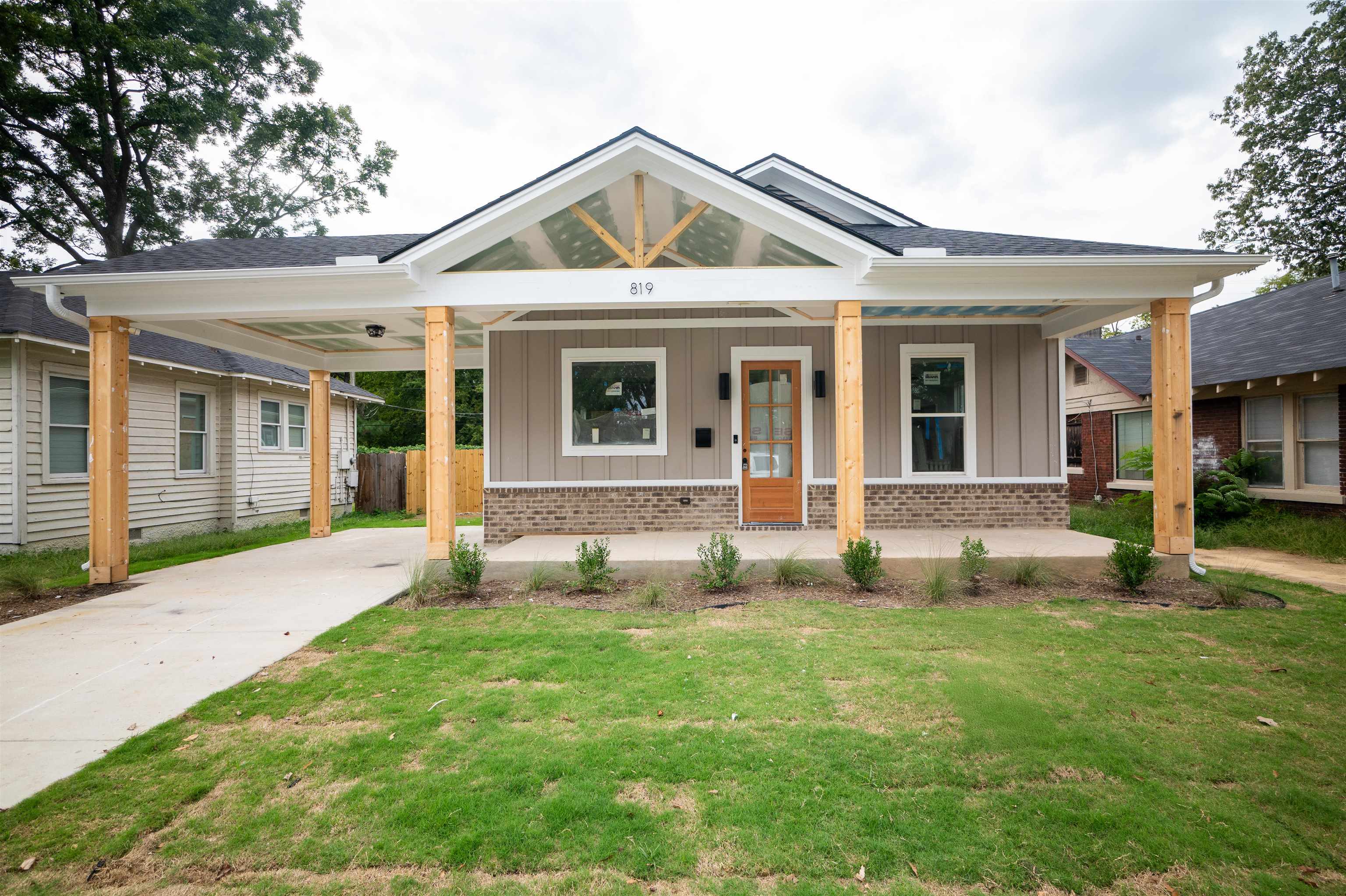 a front view of a house with a yard and trees