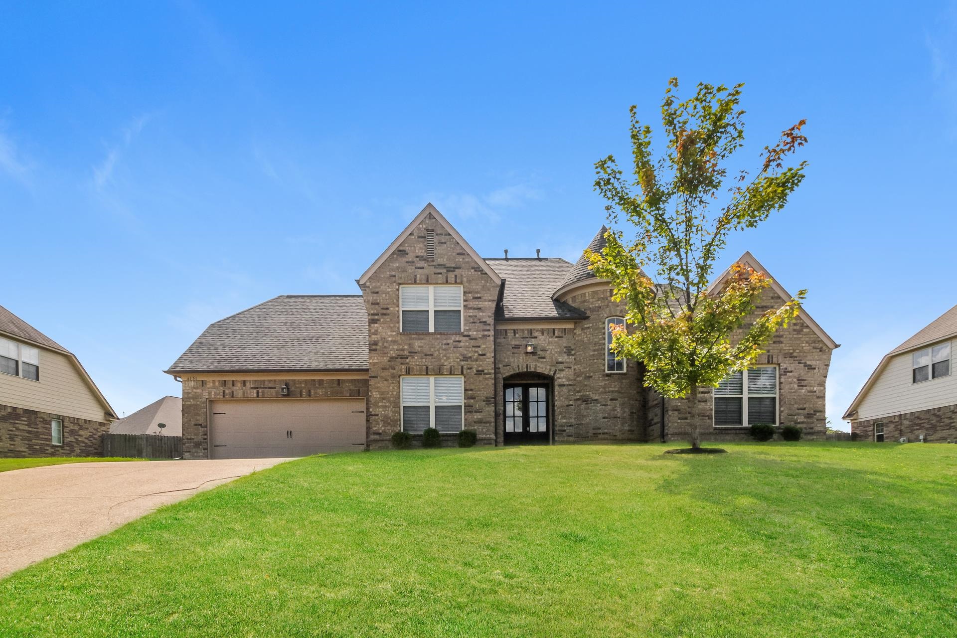 View of front of property featuring a garage and a front lawn